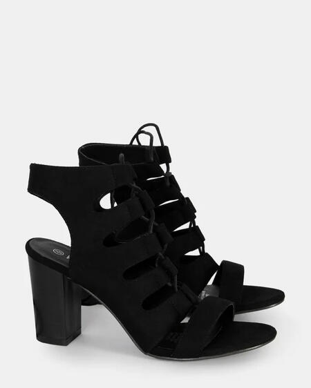 A pair of chic black high heels from Wildfire Shoes featuring a bold block heel, lace-up front, and stylish cut-out details for a trendy and elegant look.